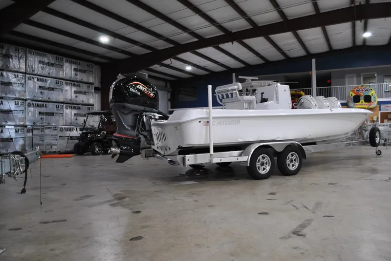 Slide: The Image of 2025 Contender 25 Bay boat on trailer in a spacious indoor facility. - 2