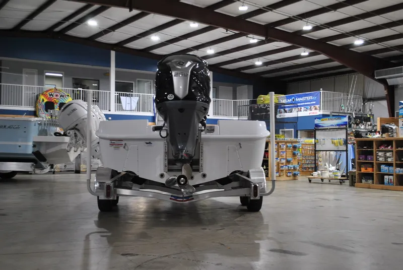 Slide: The Image of 2025 Contender 25 Bay boat displayed indoors with powerful outboard motor. - 3