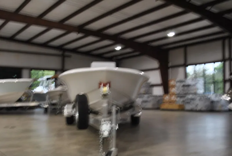 Slide: The Image of 2025 Contender 25 Bay boat in a spacious indoor showroom. - 6