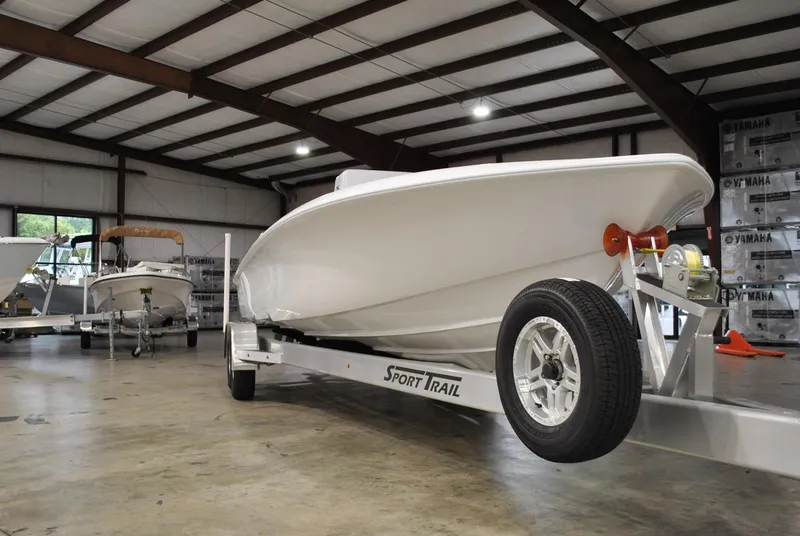 Slide: The Image of 2025 Contender 25 Bay boat on Sport Trail trailer in warehouse setting. - 7