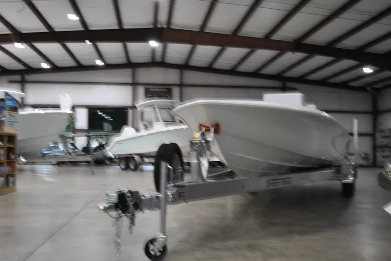 Slide: The Image of 2025 Contender 25 Bay boat in a spacious indoor showroom. - 8