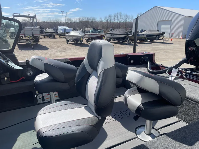 Slide: The Image of 2024 Alumacraft Competitor 205 Sport boat interior with comfortable seating in a marina setting. - 10