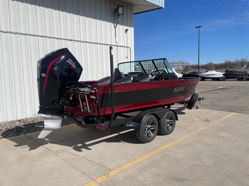 Slide: The Image of 2024 Alumacraft Competitor 205 Sport boat on trailer, parked outdoors. - 7