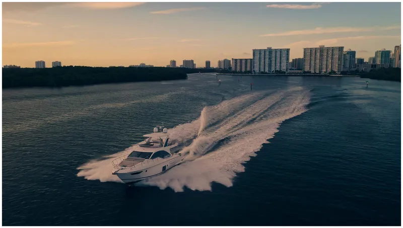Slide: The Image of Azimut 2022 Fly yacht cruising on water at sunset near city skyline. - 2