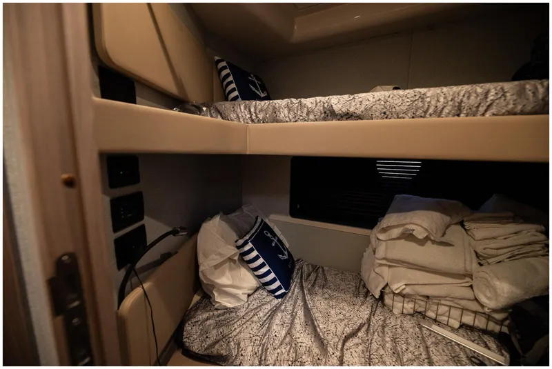 Slide: The Image of Bunk beds in 2022 Azimut Fly yacht cabin with nautical-themed pillows and bedding. - 47
