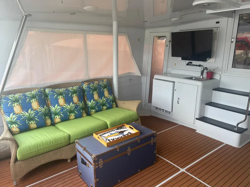 Slide: The Image of 1998 Hatteras 52 Cockpit Motor Yacht interior with tropical decor and entertainment area. - 19