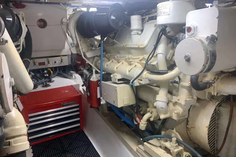 Slide: The Image of Engine room of 1998 Hatteras 52 Cockpit Motor Yacht with visible machinery and tool chest. - 34