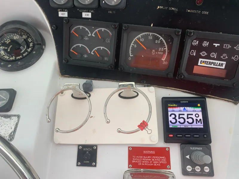 Slide: The Image of Control panel of a 1998 Hatteras 52 Cockpit Motor Yacht with gauges and navigation display. - 8