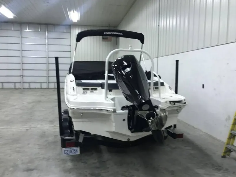 Slide: The Image of 2020 Chaparral 21 SSi OB boat in a garage, rear view with outboard motor. - 1