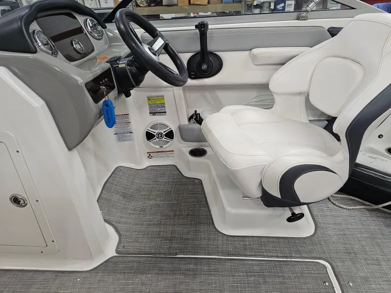Slide: The Image of 2020 Chaparral 21 SSi OB boat interior with steering wheel and white seating. - 13