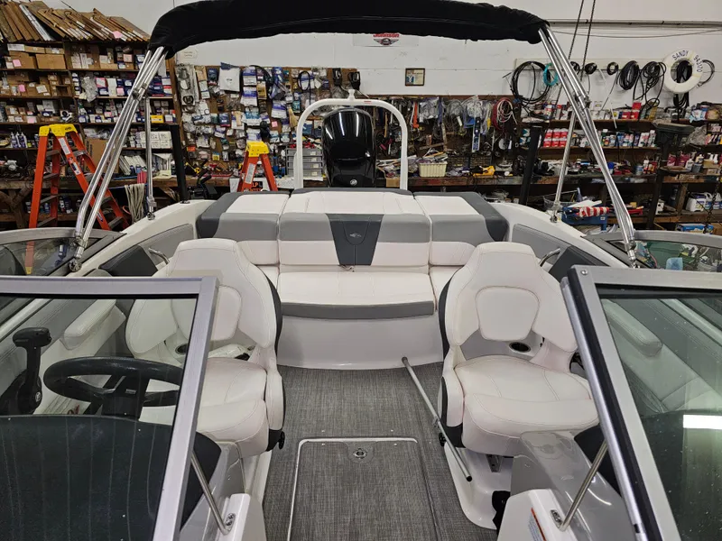 Slide: The Image of 2020 Chaparral 21 SSi OB boat interior with white seating in a workshop setting. - 17