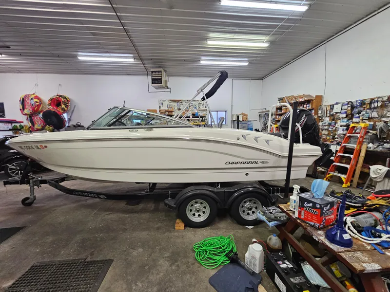 Slide: The Image of 2020 Chaparral 21 SSi OB boat in a garage, surrounded by tools and equipment. - 25