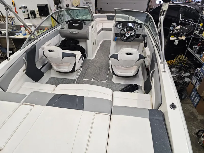 Slide: The Image of 2020 Chaparral 21 SSi OB boat interior with seating and steering wheel in a workshop. - 8