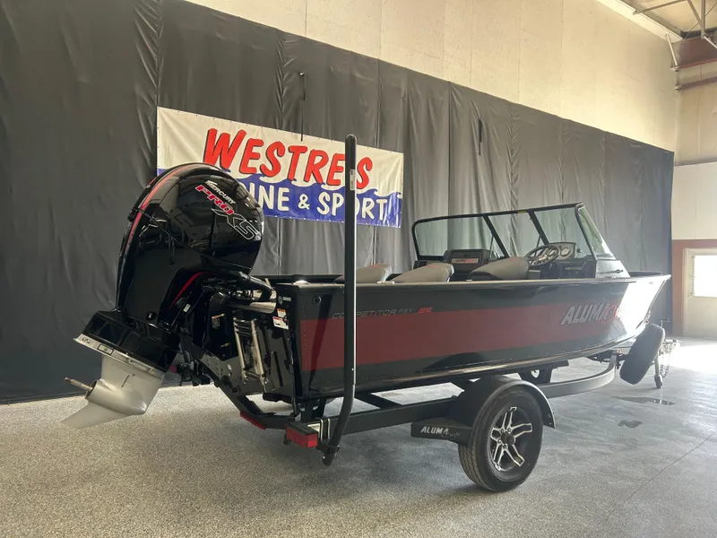 Slide: The Image of 2024 Alumacraft Competitor FSX 185 boat on trailer in showroom setting. - 1