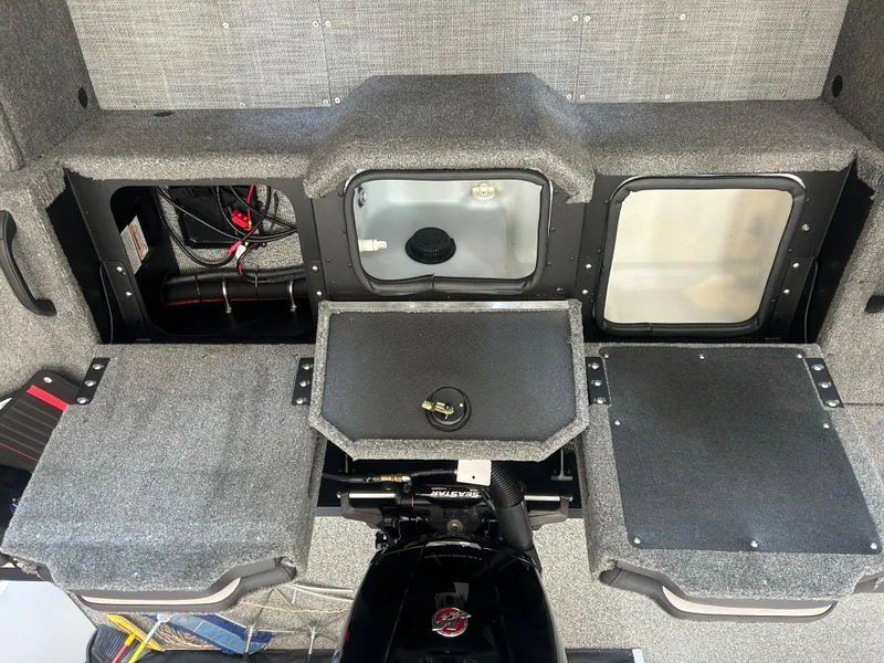 Slide: The Image of 2024 Alumacraft Competitor FSX 185 boat interior with storage compartments and motor. - 16