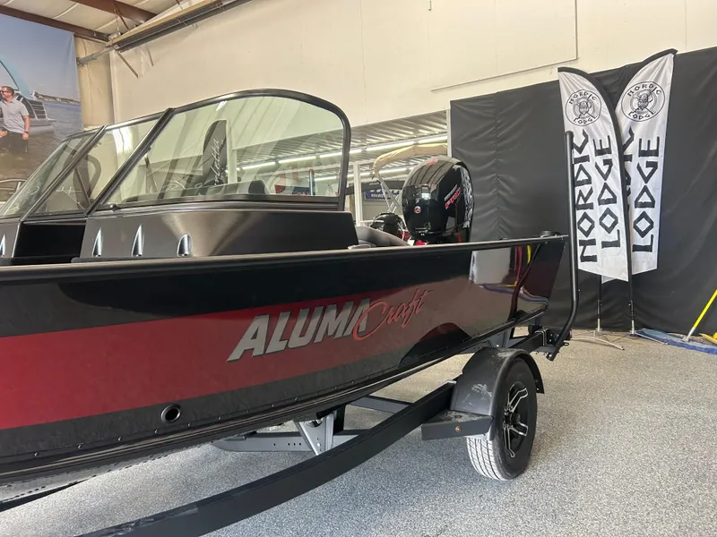 Slide: The Image of 2024 Alumacraft Competitor FSX 185 boat displayed indoors with Nordic Lodge banners. - 4