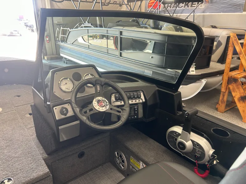 Slide: The Image of 2024 Alumacraft Competitor FSX 185 boat interior with steering wheel and dashboard controls. - 9