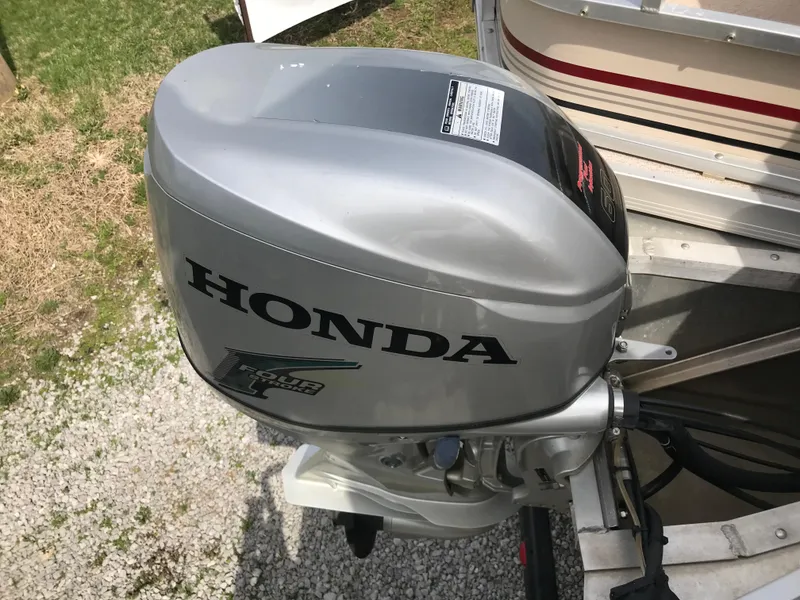 Slide: The Image of Silver Honda outboard motor on a 2010 Weeres Fisherman Deluxe 180 boat. - 2