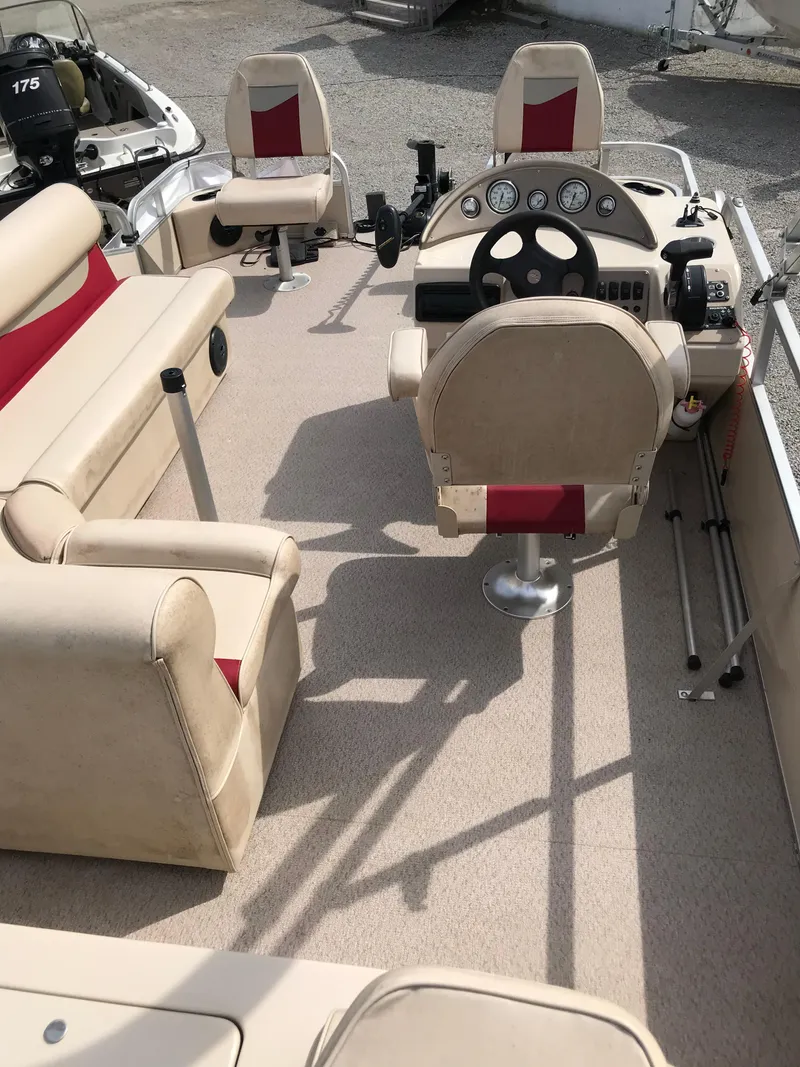 Slide: The Image of 2010 Weeres Fisherman Deluxe 180 interior with beige seating and steering console. - 7
