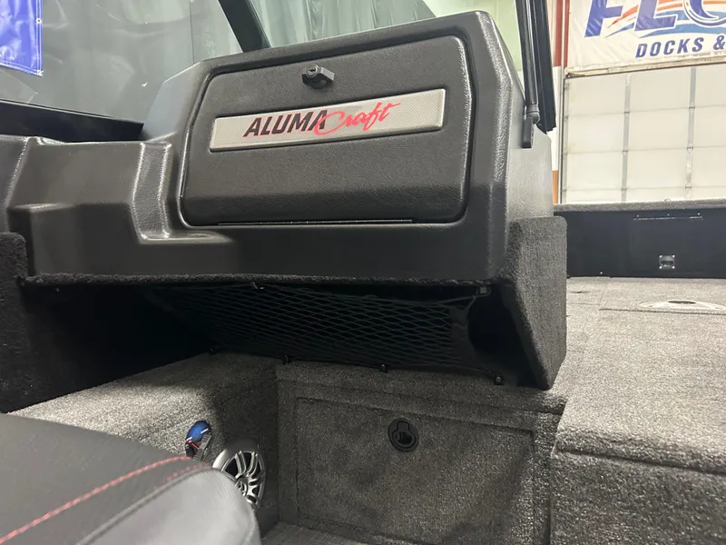 Slide: The Image of 2024 Alumacraft Competitor FSX 175 boat interior with storage compartment and speaker. - 13