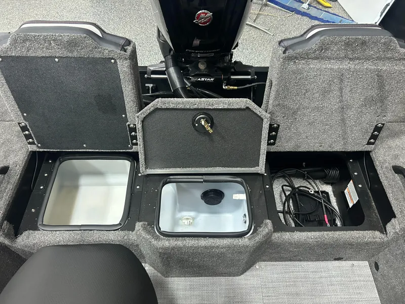 Slide: The Image of 2024 Alumacraft Competitor FSX 175 boat storage compartments with open lids and visible wiring. - 17