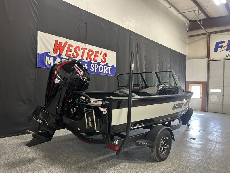 Slide: The Image of 2024 Alumacraft Competitor FSX 175 boat displayed indoors at Westre's Marine and Sport. - 2