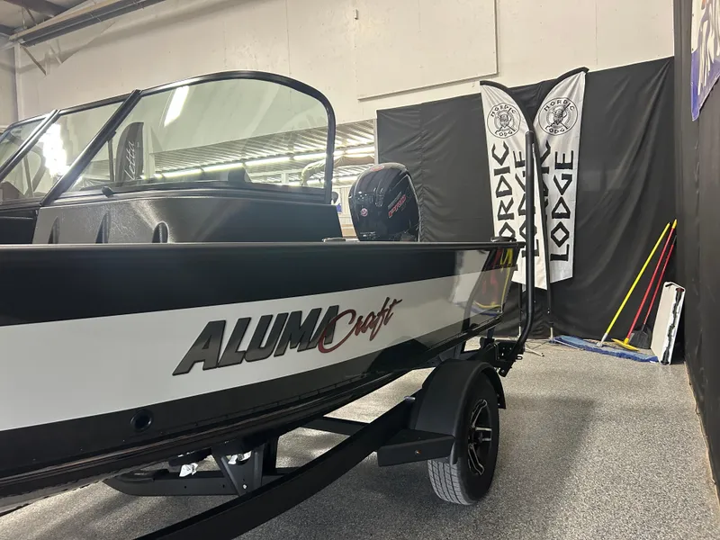 Slide: The Image of 2024 Alumacraft Competitor FSX 175 boat displayed indoors with Nordic Lodge banners. - 6