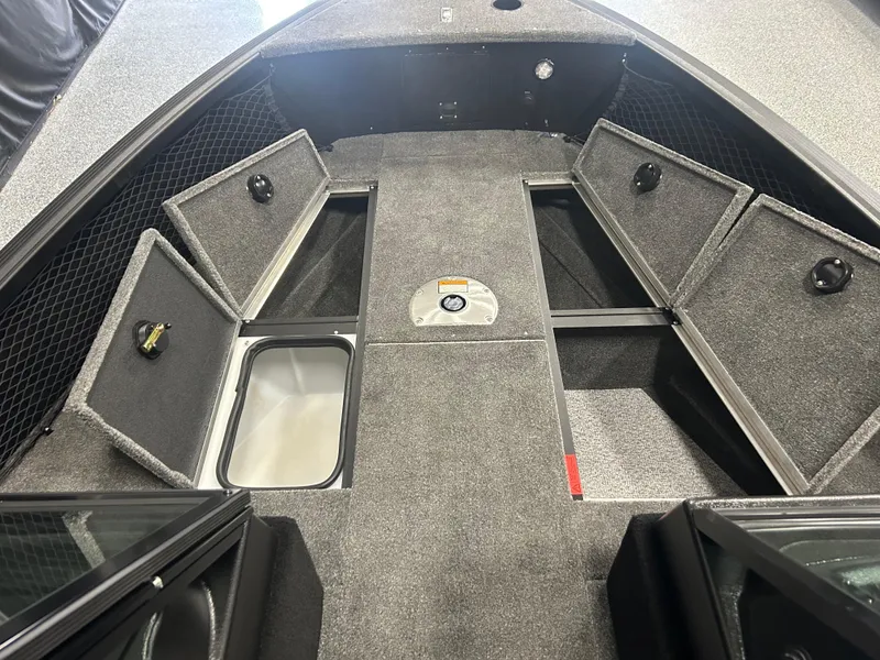 Slide: The Image of 2024 Alumacraft Competitor FSX 175 boat interior with storage compartments and carpeted flooring. - 8