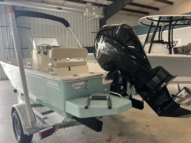 Slide: The Image of 2022 Boston Whaler 170 Montauk boat with outboard motor in a showroom. - 3