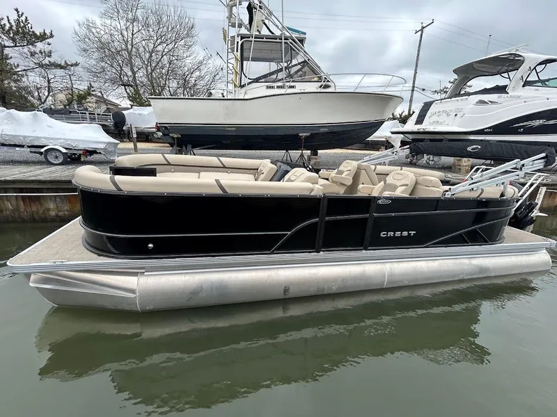 Slide: The Image of 2024 Crest Classic DLX 240 SLC pontoon boat docked in marina. - 1