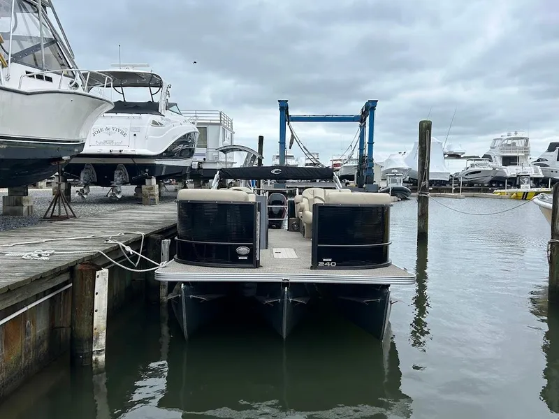 Slide: The Image of 2024 Crest Classic DLX 240 SLC pontoon boat docked at marina under cloudy sky. - 3
