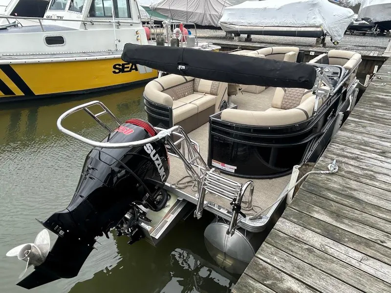 Slide: The Image of 2024 Crest Classic DLX 240 SLC pontoon boat docked with Suzuki outboard motor. - 4