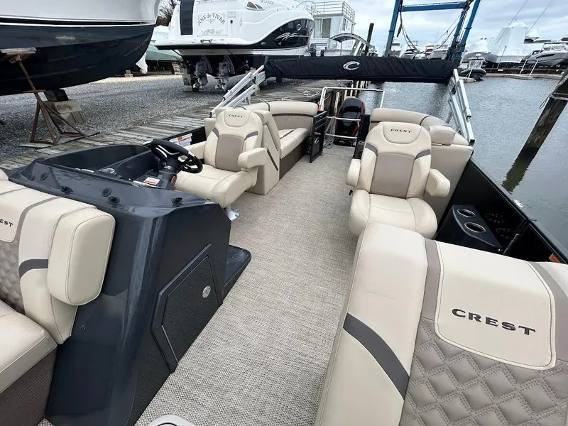 Slide: The Image of 2024 Crest Classic DLX 240 SLC pontoon boat with luxurious seating and modern design. - 7