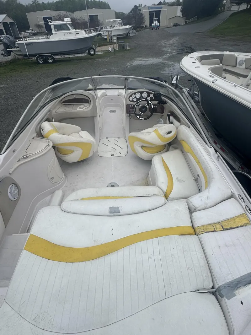 Slide: The Image of 2006 Tahoe 215 boat interior with white and yellow seating, steering console, and spacious layout. - 4
