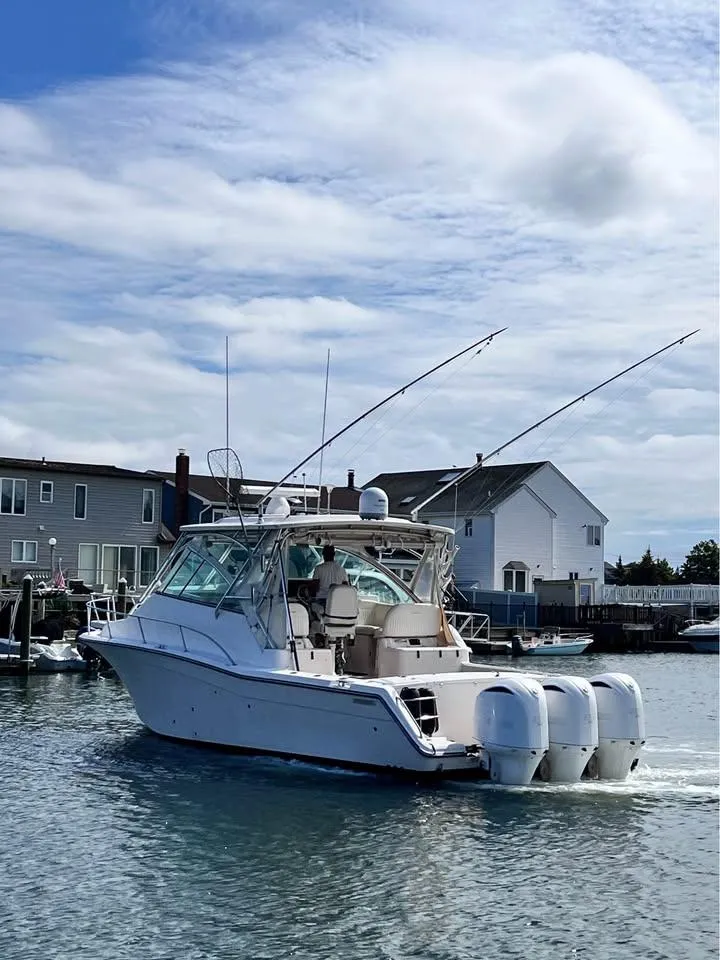 Slide: The Image of 2005 Grady-White Express 360 boat cruising near waterfront homes under a cloudy sky. - 1