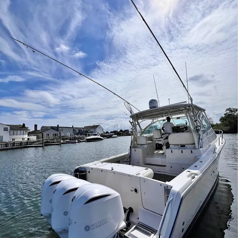 Slide: The Image of 2005 Grady-White Express 360 boat on water, clear sky, residential backdrop. - 19