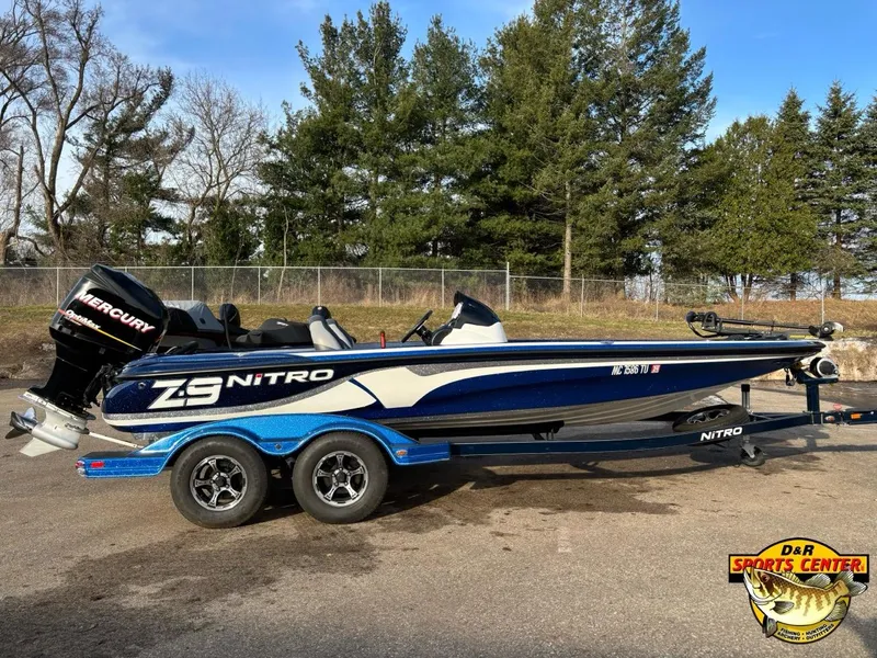 Slide: The Image of 2015 Nitro Z-9 boat with Mercury engine, parked outdoors near trees. - 2