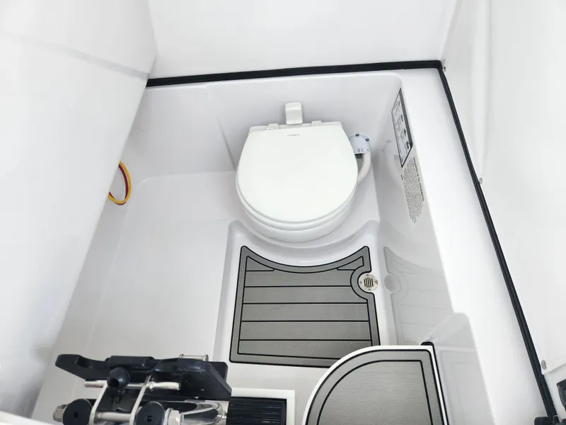 Slide: The Image of 2025 Sportsman Open 262 Center Console boat interior with toilet and storage area. - 18