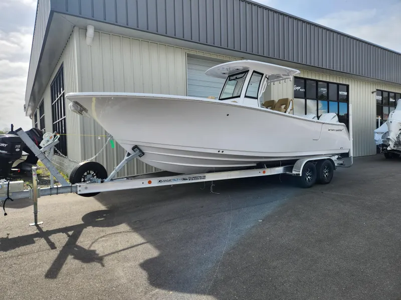 Slide: The Image of 2025 Sportsman Open 262 Center Console boat on trailer outside a building. - 2