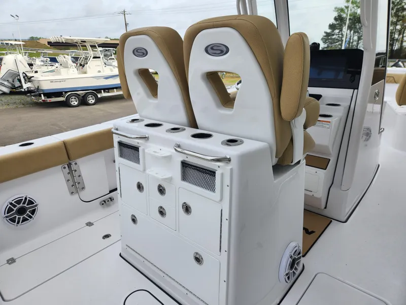Slide: The Image of 2025 Sportsman Open 262 Center Console boat interior with tan seating and storage compartments. - 25