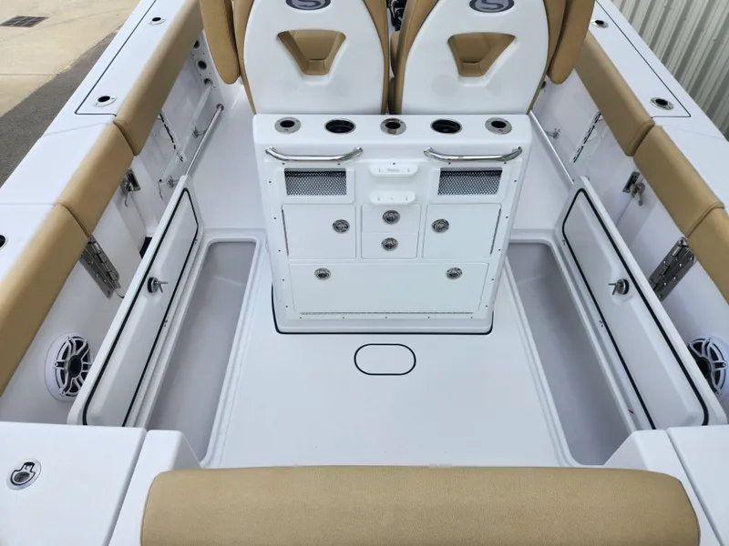 Slide: The Image of 2025 Sportsman Open 262 Center Console boat interior with tan seating and storage compartments. - 31