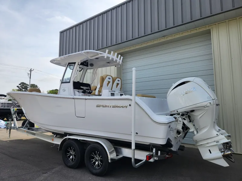Slide: The Image of 2025 Sportsman Open 262 Center Console boat on trailer, parked outside a building. - 4