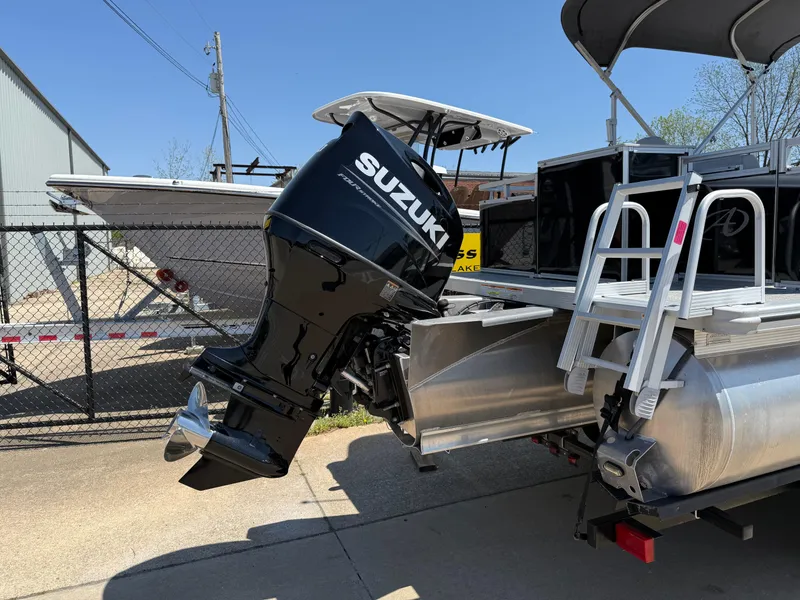 Slide: The Image of 2022 Avalon Venture Fish boat with Suzuki outboard motor, docked near a fence. - 21