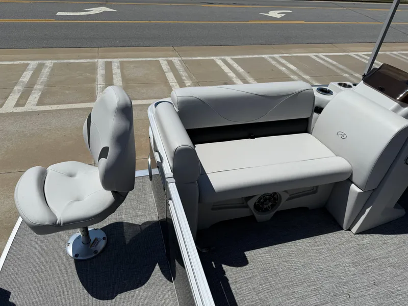 Slide: The Image of 2022 Avalon Venture Fish boat interior with gray seating and console, parked on pavement. - 32