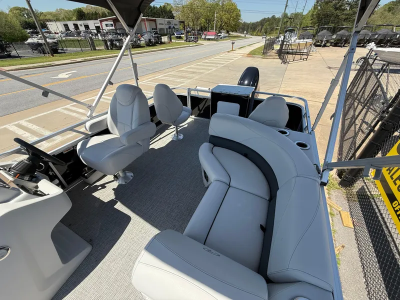 Slide: The Image of 2022 Avalon Venture Fish boat interior with seating and steering console, parked near a road. - 37