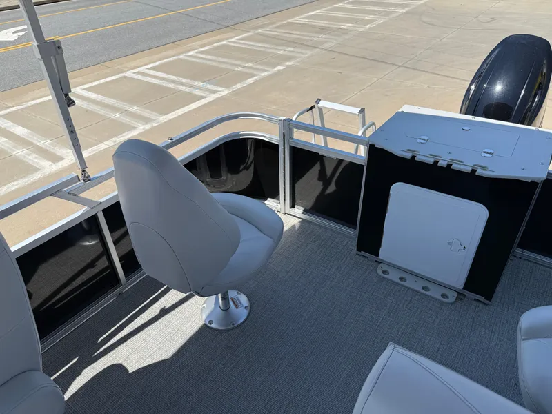 Slide: The Image of 2022 Avalon Venture Fish boat interior with seating and storage, docked on a sunny day. - 47