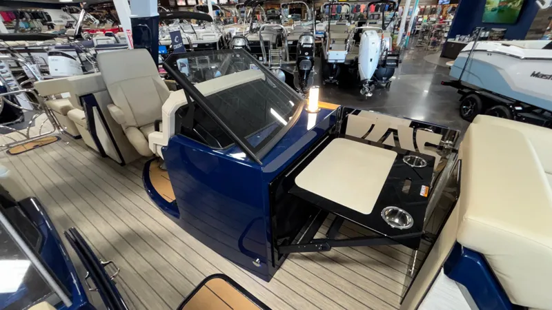 Slide: The Image of 2025 Balise Helix 26C boat interior with seating and table, displayed in a showroom. - 24