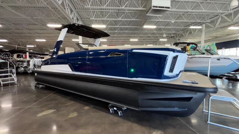 Slide: The Image of 2025 Balise Helix 26C boat in showroom, sleek design, blue and white exterior. - 3