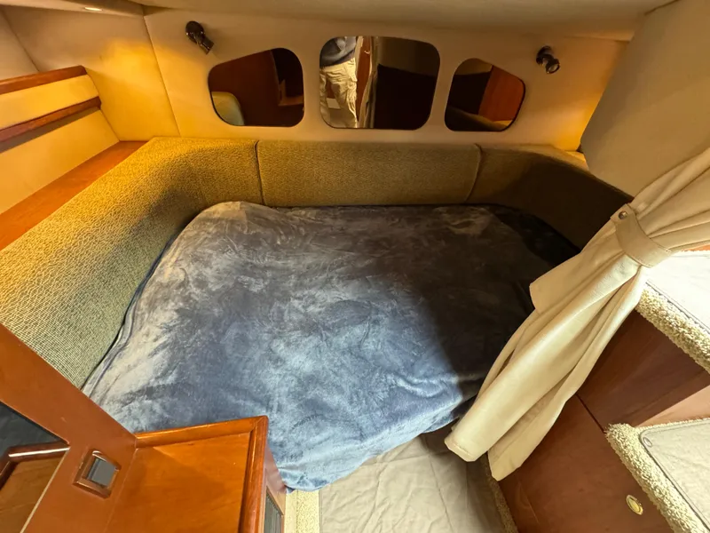 Slide: The Image of 2001 Cruisers Yachts 3470 Express cabin with cozy bed and wooden interior. - 12