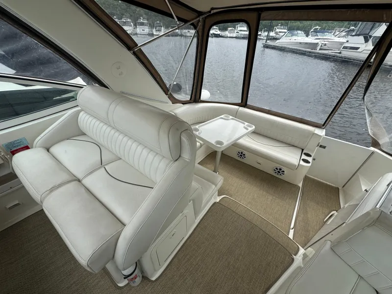 Slide: The Image of 2001 Cruisers Yachts 3470 Express interior with white leather seating and lake view. - 14
